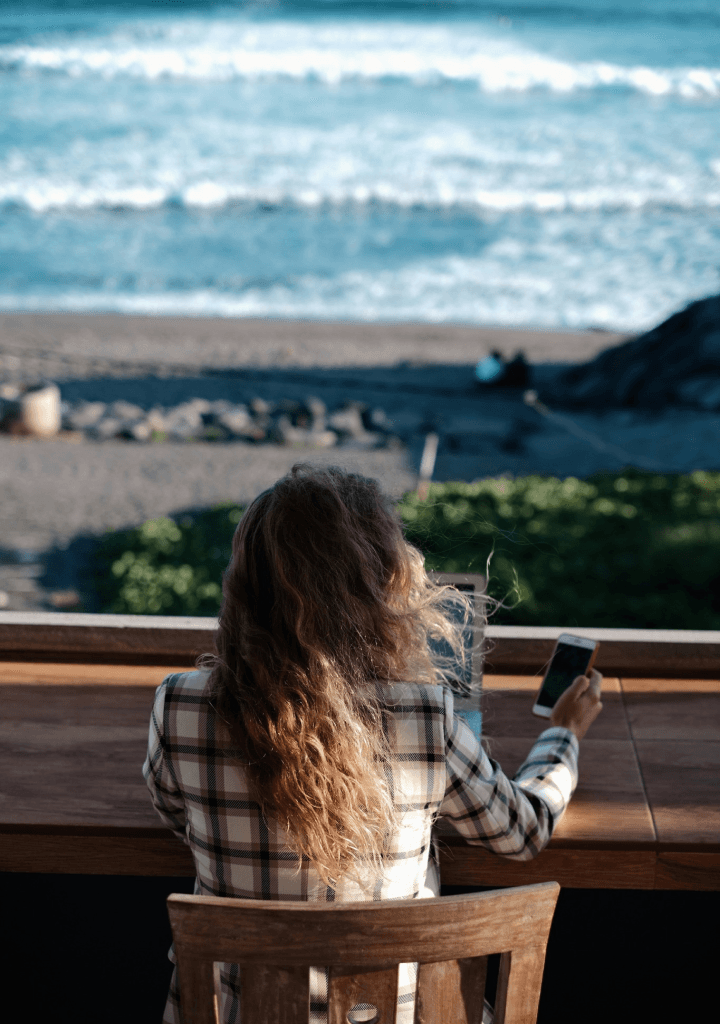 Girl using her computer with a view of the beach